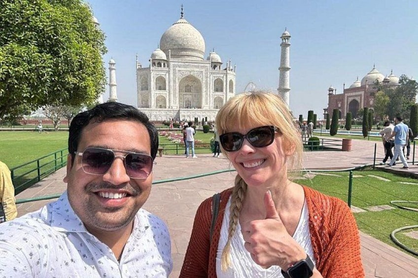 A person taking a selfie with the Taj Mahal in the background. 4