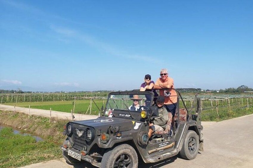 Un vehículo todoterreno negro con un grupo de personas en una carretera rural. 4