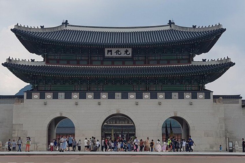 Ein traditionelles koreanisches Tor mit mehreren Bögen und einem Schild mit chinesischen Schriftzeichen. 4