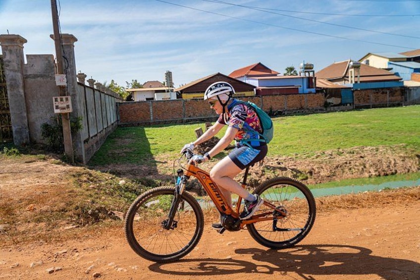 A person riding a mountain bike on a dirt path. 2