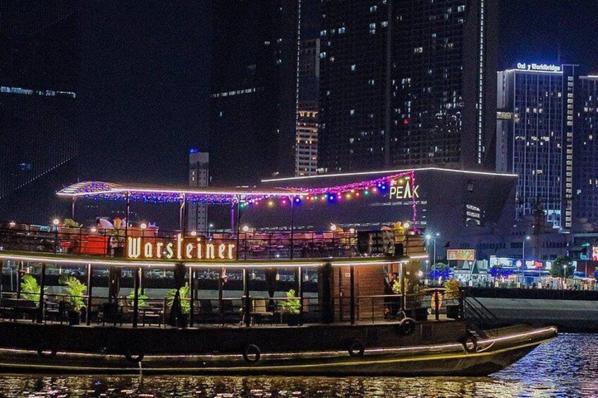 Un bateau abritant un restaurant appelé « Warsteiner » était amarré pendant la nuit, avec les bâtiments de la ville en arrière-plan. 4