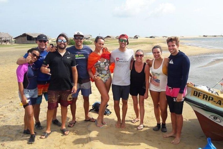 Un grupo de personas en una playa, con un barco identificado como 'DFRP-4' al fondo. 2