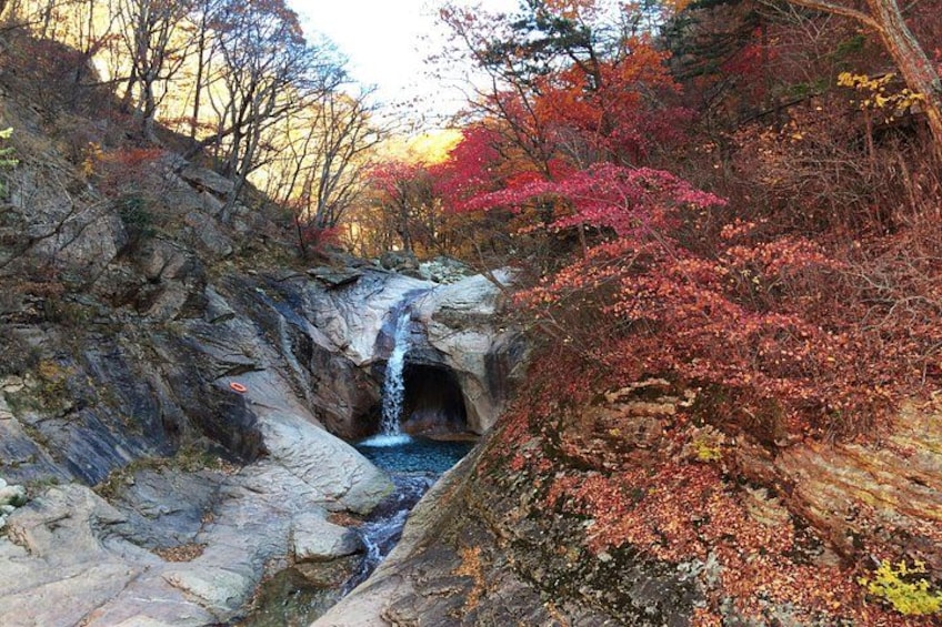 Una cascada en un desfiladero rocoso con follaje otoñal. 5