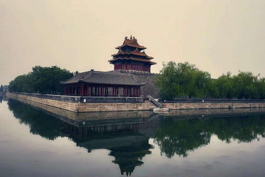 A traditional Chinese building with a reflection in the water, surrounded by trees. 2