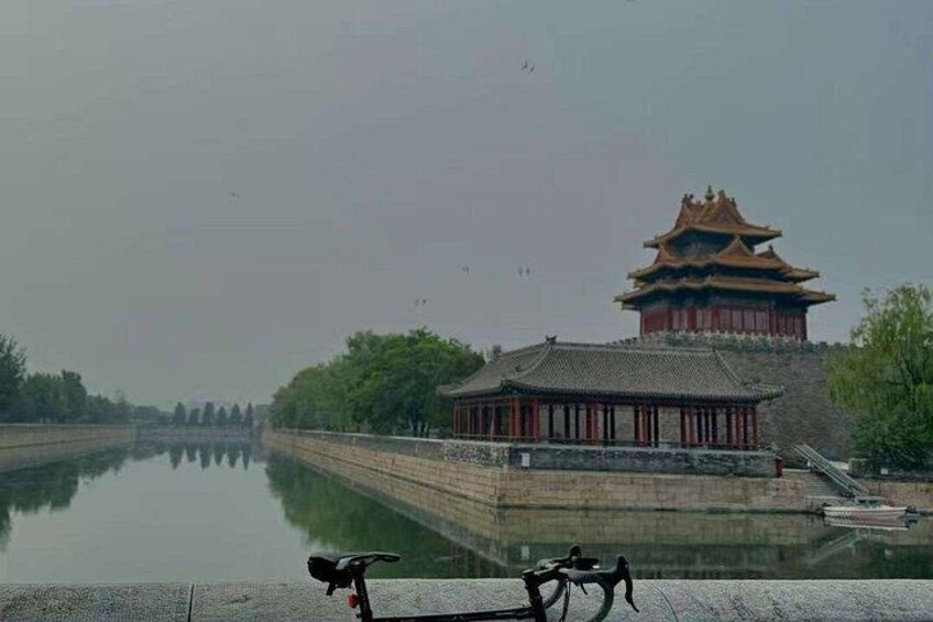 A traditional Chinese building with a reflection in the water, a bicycle in the foreground, and a clear sky. 3