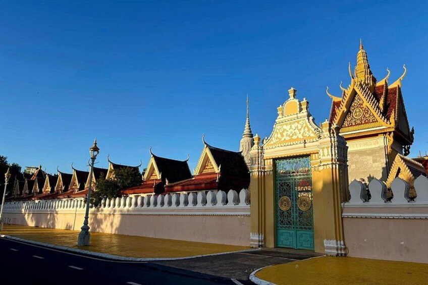Un templo tailandés tradicional con arquitectura ornamentada, un cielo azul despejado y un patio bien cuidado. 4