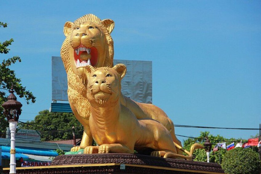 Une grande statue de lion doré, représentant un lion rugissant et un lion au repos. 3