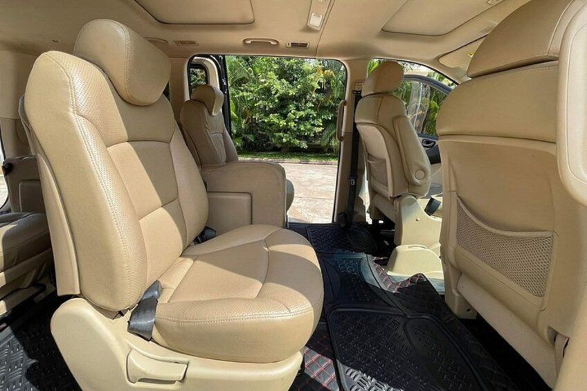 L'intérieur d'une voiture avec des sièges en cuir beige, une console centrale et un rétroviseur. 5