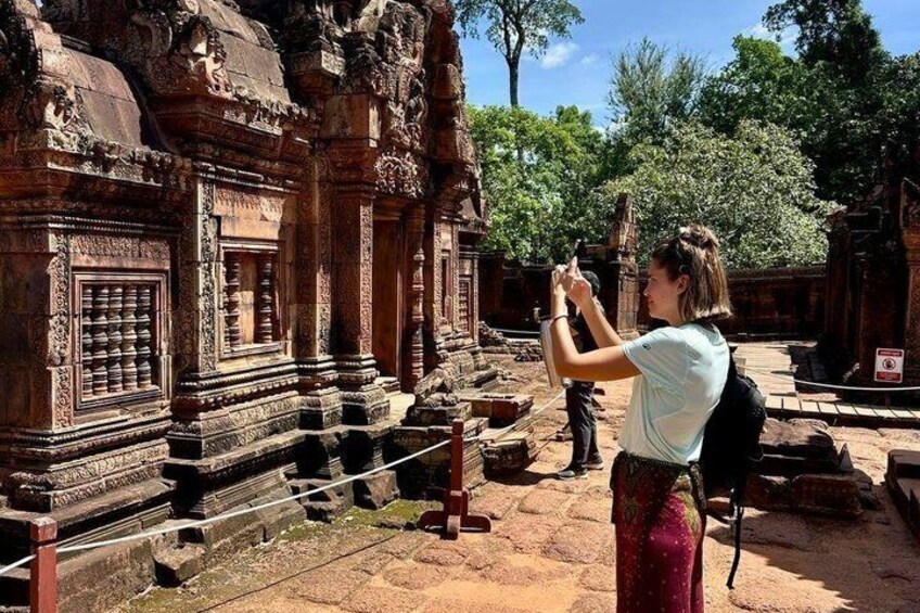 Una persona fotografa un tempio con elaborate decorazioni e colonne. 2
