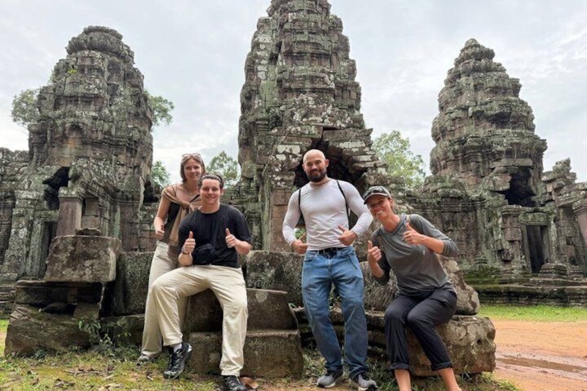 Four people posing in front of ancient stone structures. 4