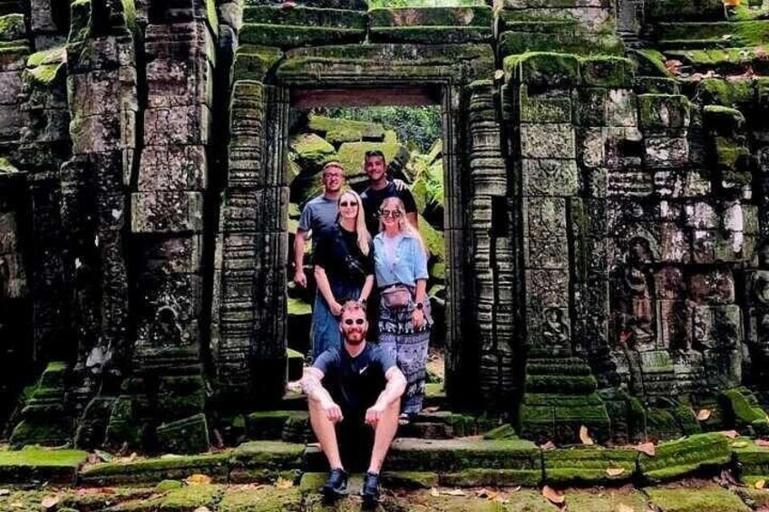 Un grupo de personas posando frente a una antigua arquitectura de piedra. 1