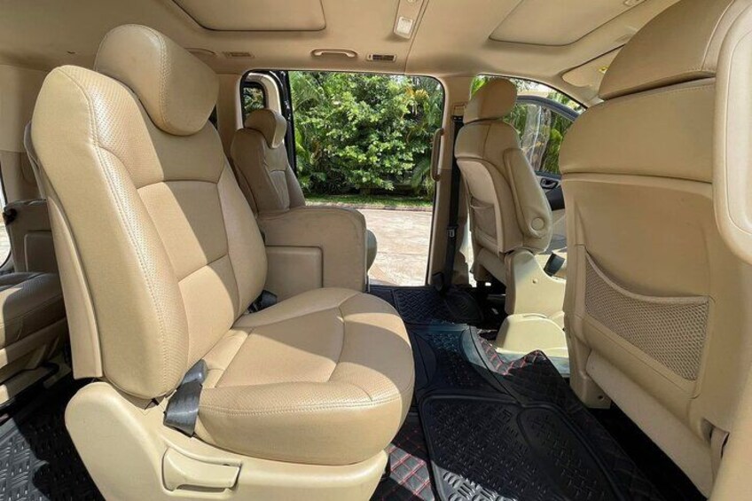 El interior de un coche con asientos de cuero color beige y una alfombra de suelo negra. 5