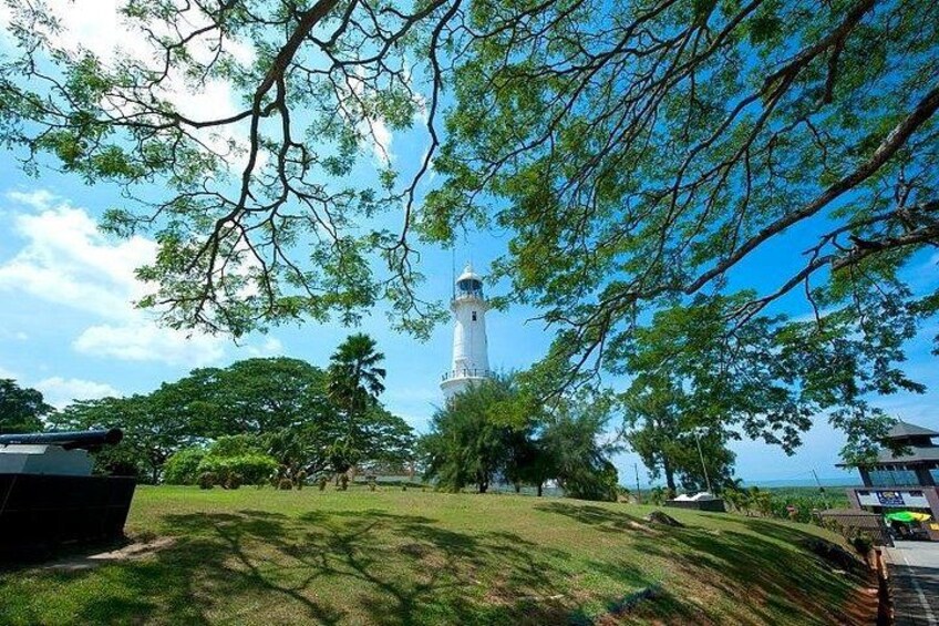 Un phare entouré d’arbres et d’herbe. 1
