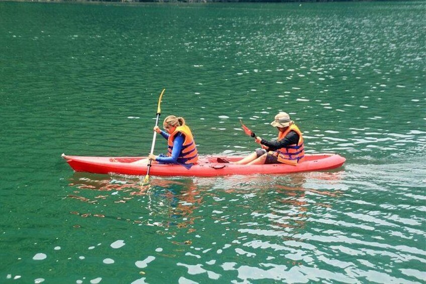 Two people kayaking on a green lake. 4
