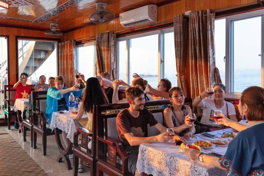 People dining at a restaurant with wooden interiors and large windows overlooking the sea. 3