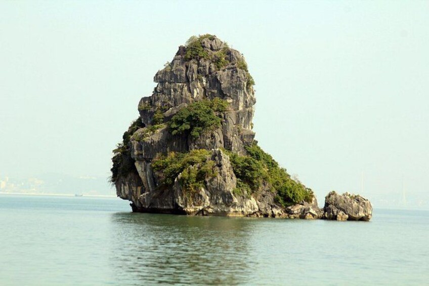 A large rock formation surrounded by calm water. 3