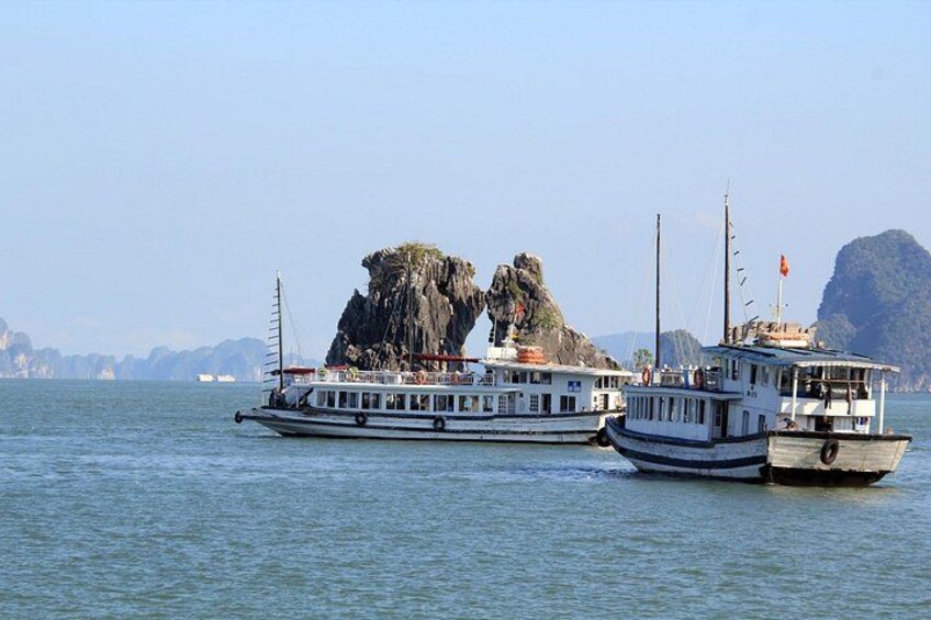 A ferry with passengers, a rocky island, and a clear sky. 3