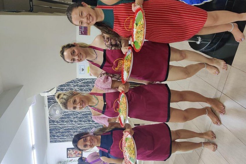 Vier personen in een keuken die borden met eten vasthouden. 4