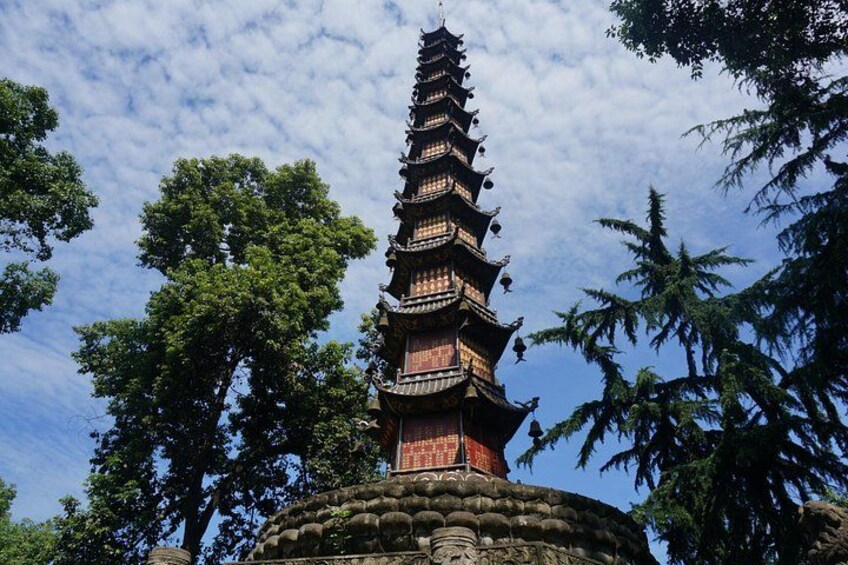 Una pagoda escalonada con base de piedra, rodeada de árboles. 2