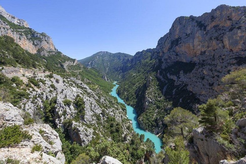 A turquoise river winding through a rocky canyon with steep cliffs and sparse vegetation. 2