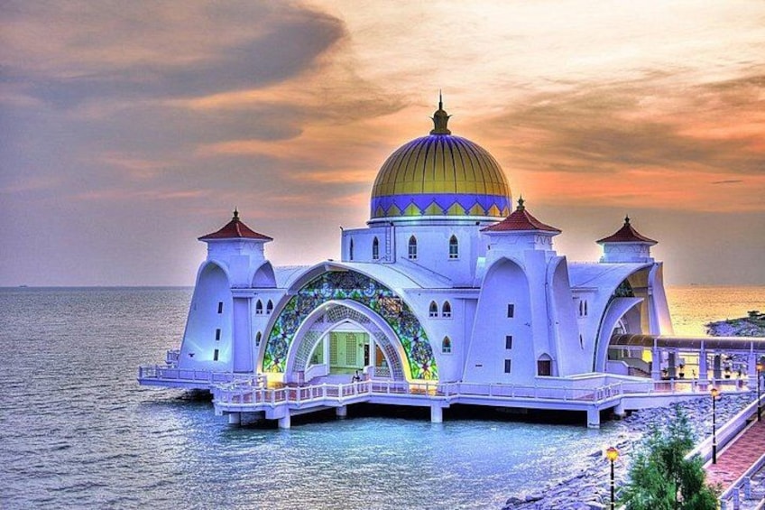 Eine weiße Moschee mit goldener Kuppel und Bogenportal am Meer. 5