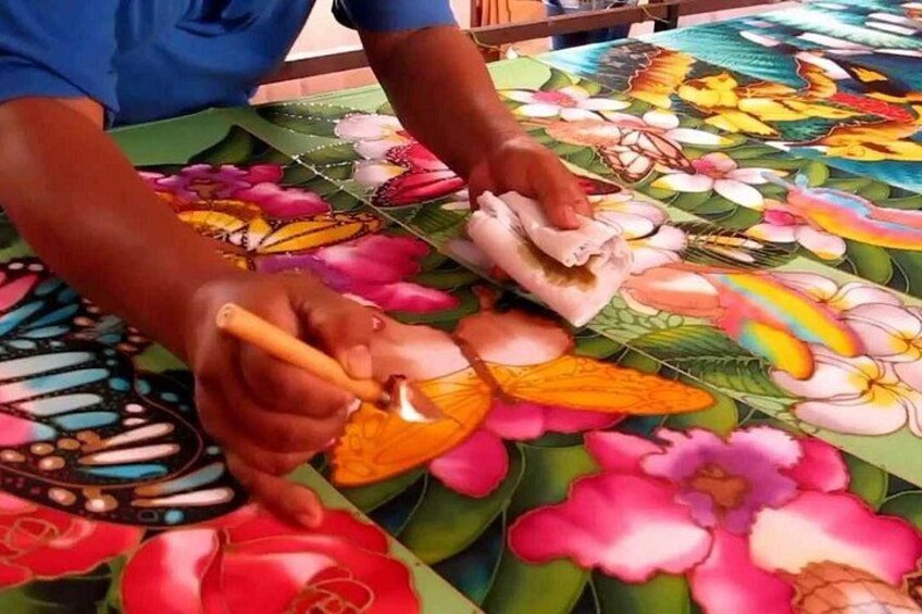 Eine Person gestaltet eine farbenfrohe Blumenmusterung auf einer Oberfläche. 4