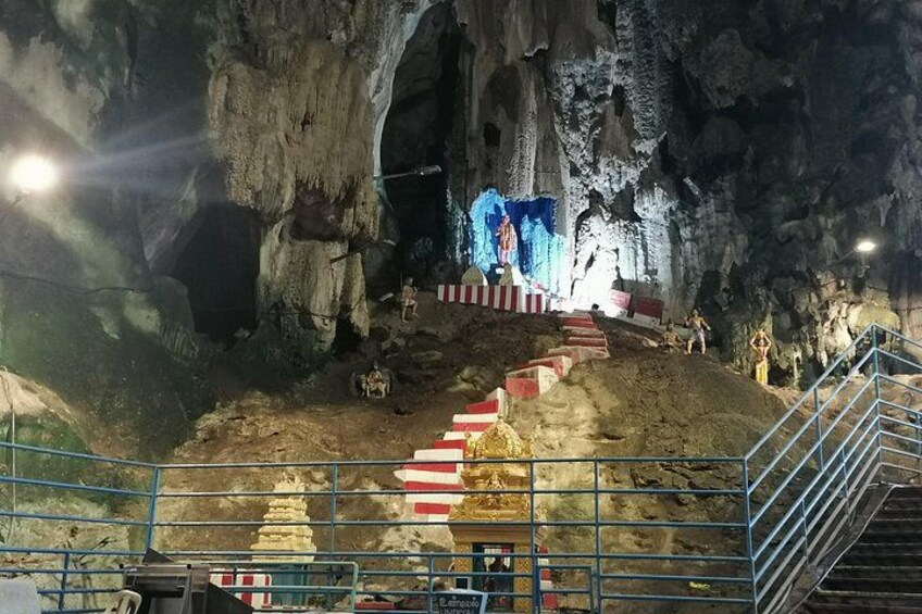 Eine Höhle mit einer Treppe, die zu einer Plattform führt, beleuchtet durch künstliches Licht. 3
