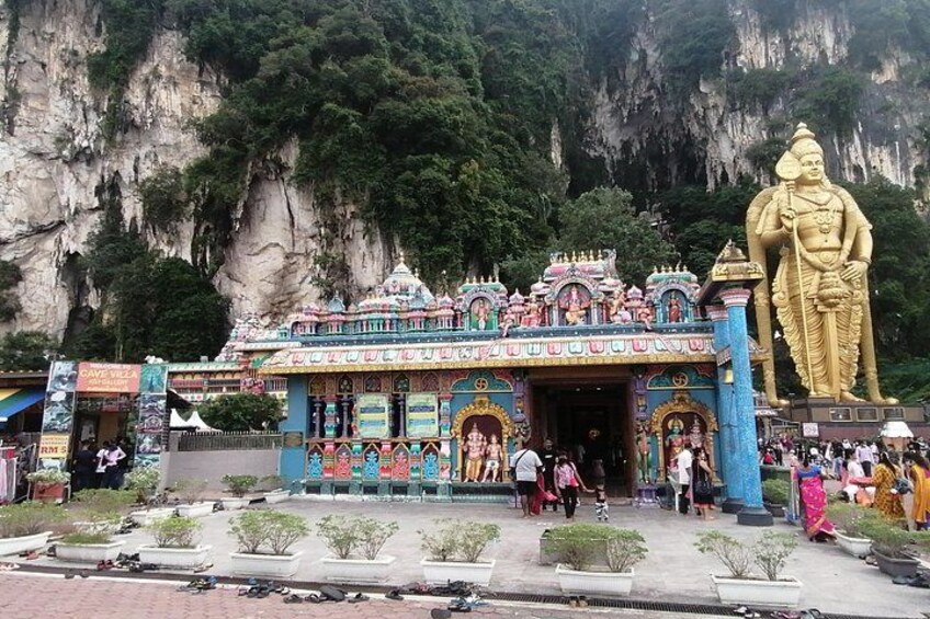 Ein Tempel mit einer großen goldenen Statue, farbenfroher Architektur und einer bergigen Kulisse. 2