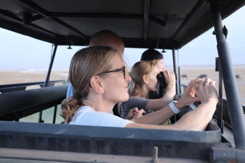 A vehicle with passengers, a desert landscape, and a clear sky. 2