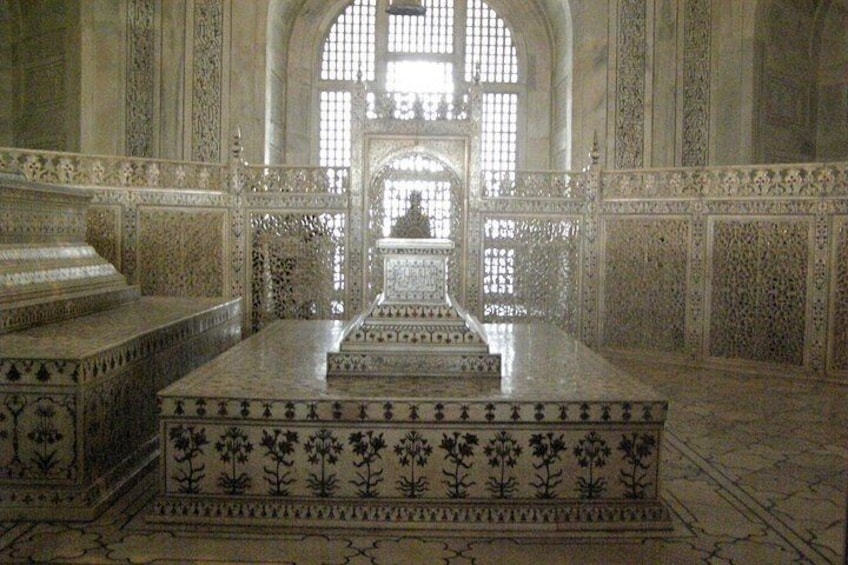 An ornate mausoleum with intricate tile work and a central tomb. 2