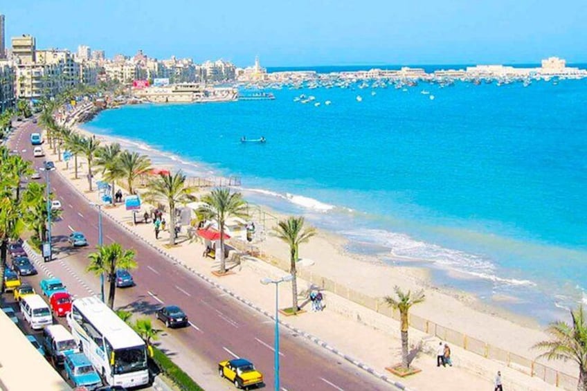 Una ciudad costera con playa, palmeras y una carretera con vehículos. 2