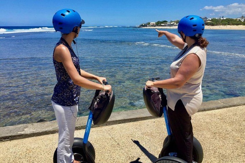 Two people on segways by the ocean. 2