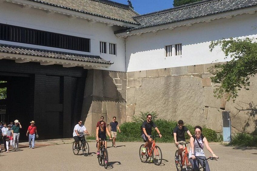 Un groupe de personnes fait du vélo devant un bâtiment blanc dont le toit est recouvert de tuiles. 3