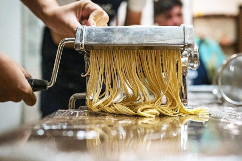 A pasta machine in use, with pasta being extruded. 5