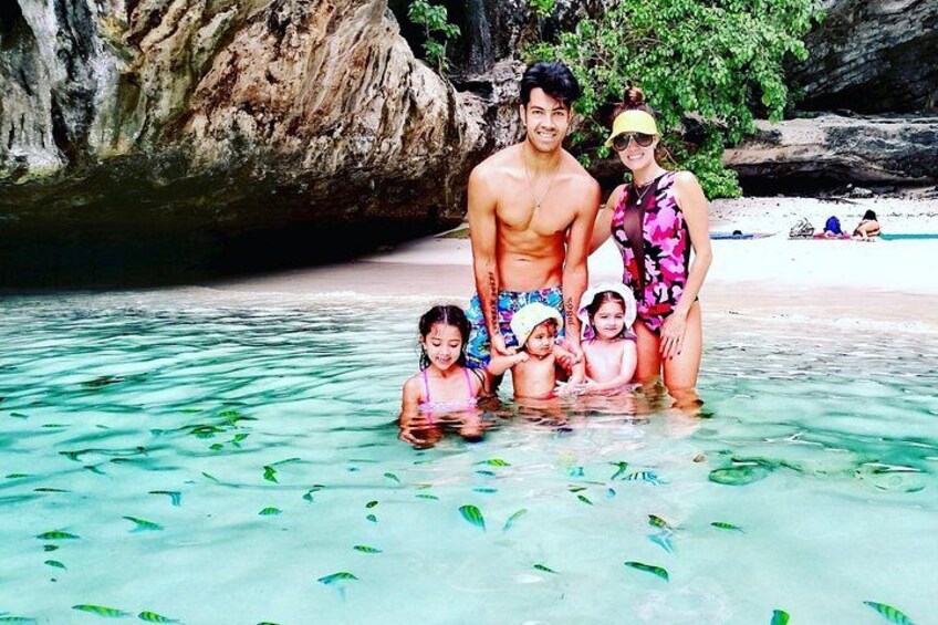 A family in clear water with a rocky background. 4