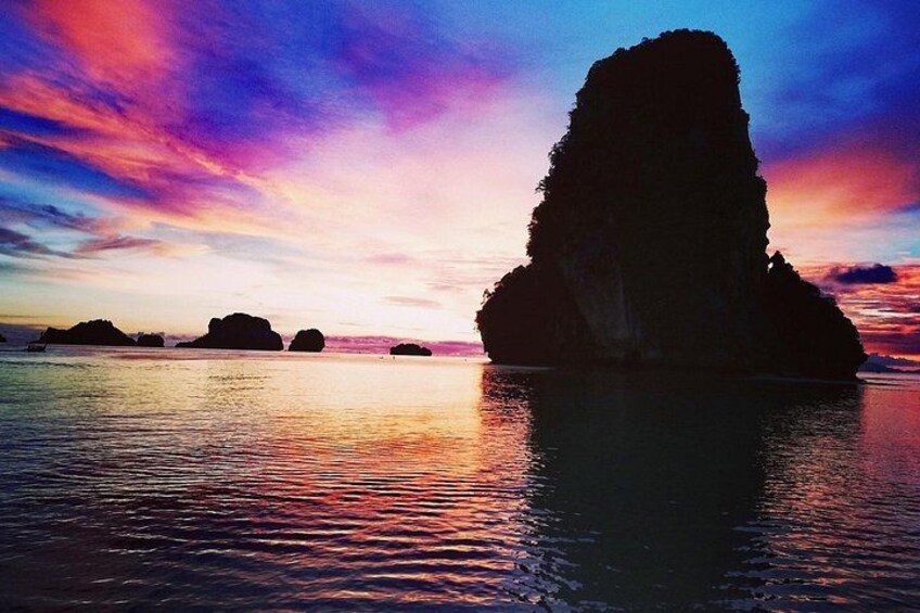 A large rock formation in the water during sunset. 5