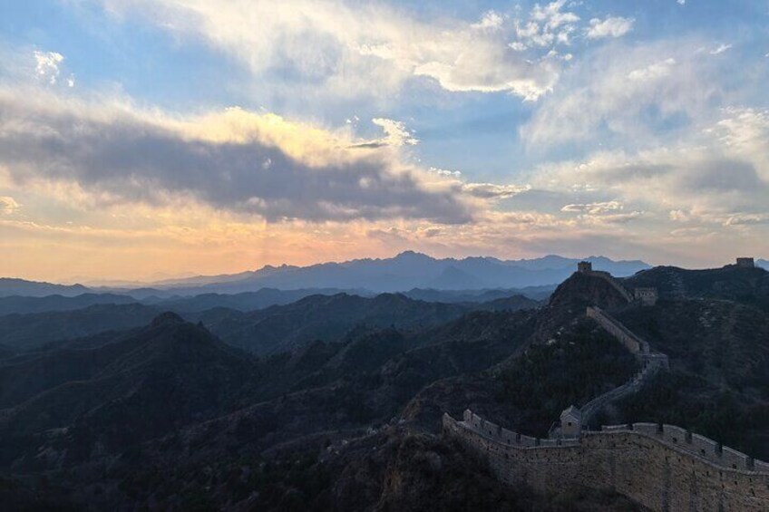 The Great Wall of China with a mountainous backdrop and a cloudy sky. 2