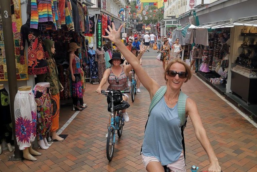 A street with shops and mannequins displaying colorful clothing. 5