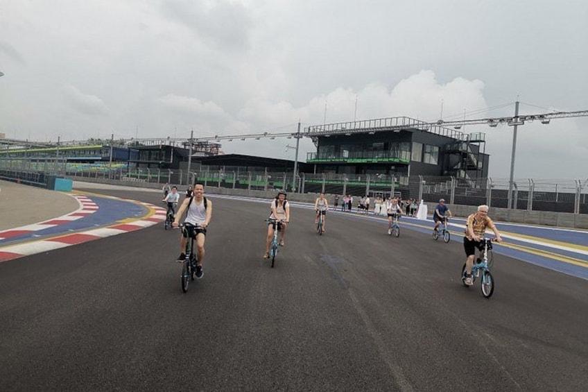 Un groupe de cyclistes sur une piste cyclable, avec un stade en arrière-plan. 2