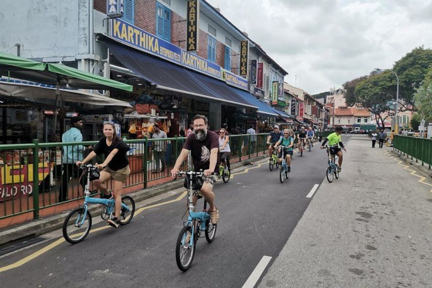 Une rue où l’on croise des cyclistes, des boutiques et un pont. 4