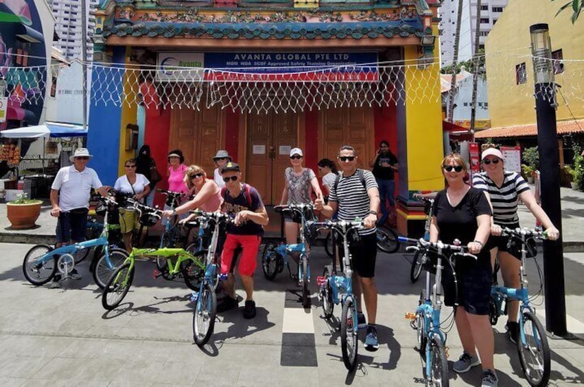 Un groupe de personnes à vélo se trouve devant un bâtiment sur lequel est apposée une enseigne indiquant « AVANTA GLOBAL PTE LTD ». 4