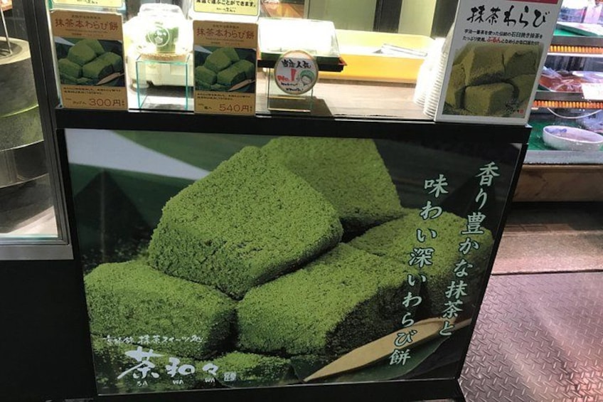 A display of green packaged food items with price tags. 5