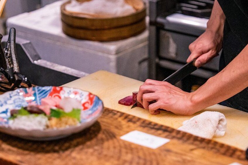 A person slicing meat on a cutting board. 4