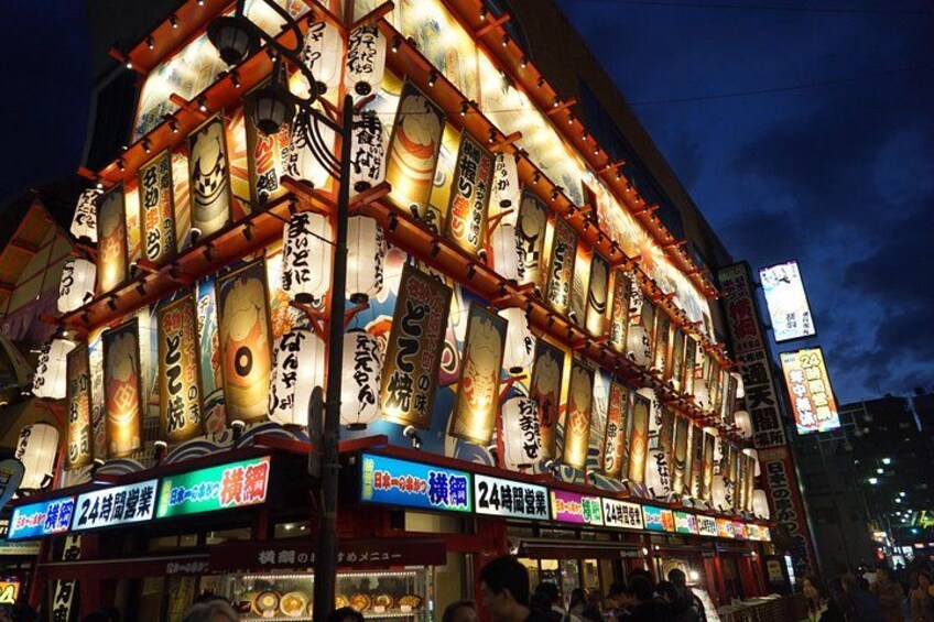 Un edificio japonés tradicional con letreros iluminados y faroles. 5