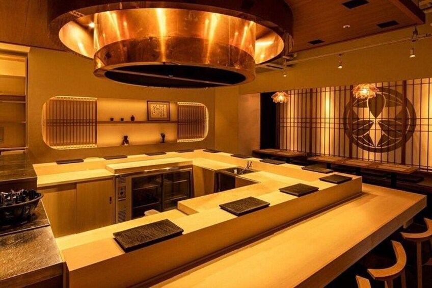 Une cuisine moderne dotée d’un long comptoir, d’éléments en cuivre et d’un mur décoratif. 4