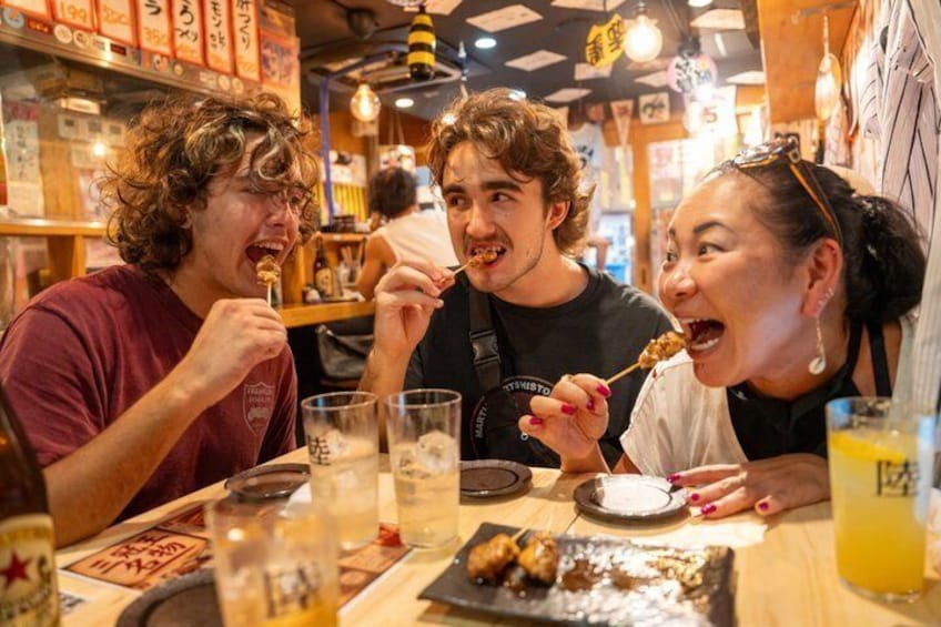 Tre personer spiser på en restaurant med borde, mad, drikke og en menu. 1