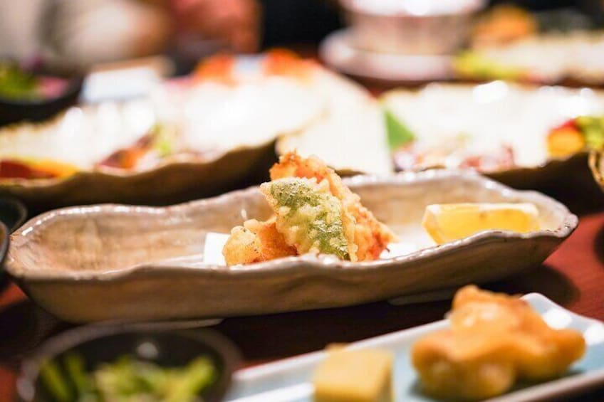 A variety of dishes on a table, including a piece of fried food in a shell and some other food items. 1