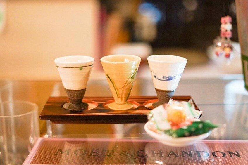 A table with three cups and a bowl of food. 4
