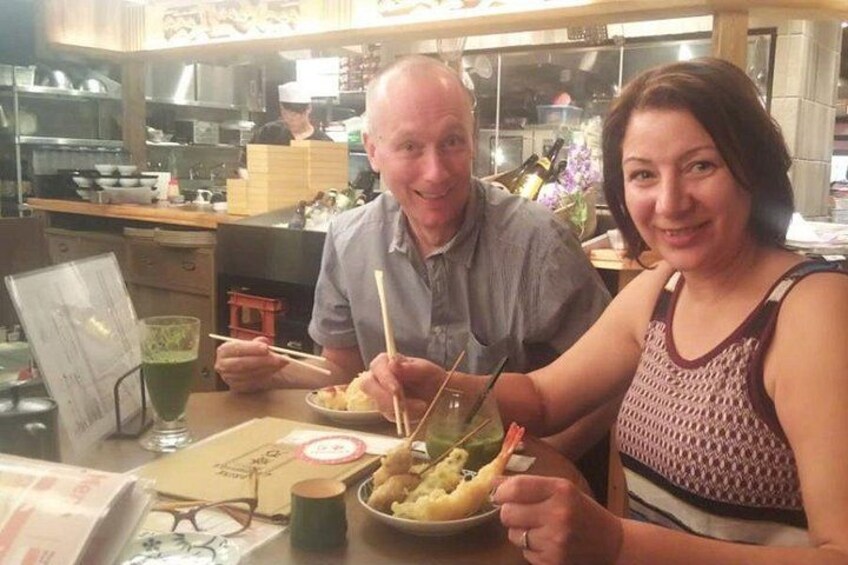 Un homme et une femme sont assis à une table devant un repas, un menu et une boisson. 2