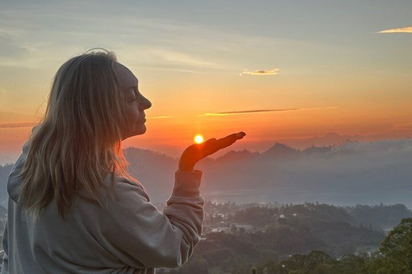 Eine Person blickt auf eine Berglandschaft bei Sonnenuntergang. 3